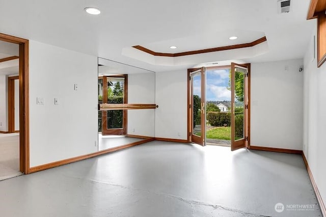 unfurnished room with baseboards, visible vents, concrete floors, and a raised ceiling