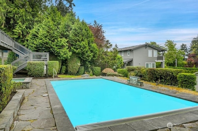 outdoor pool featuring stairs