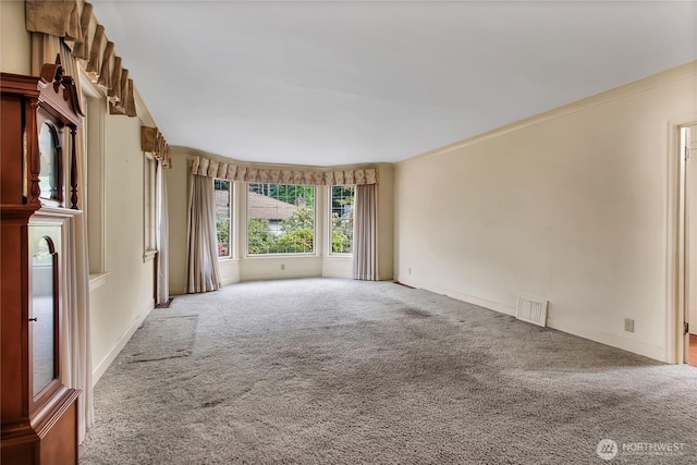 carpeted empty room with visible vents and baseboards