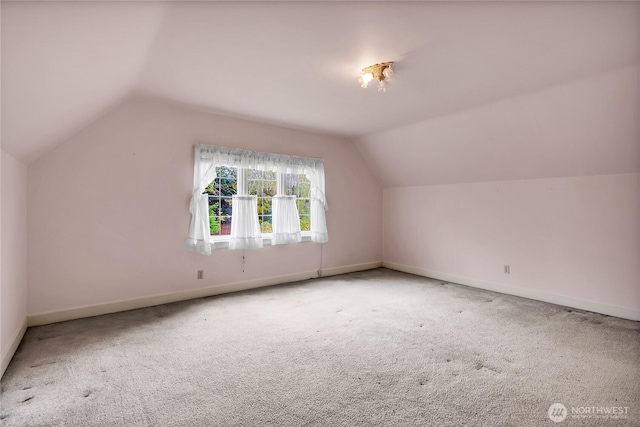 additional living space featuring carpet floors, baseboards, and vaulted ceiling