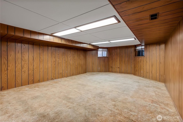 basement with carpet flooring and wood walls