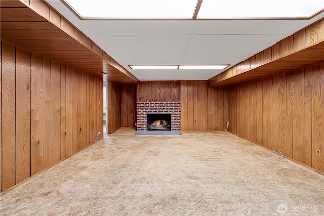 unfurnished living room featuring wood walls, carpet flooring, and a fireplace