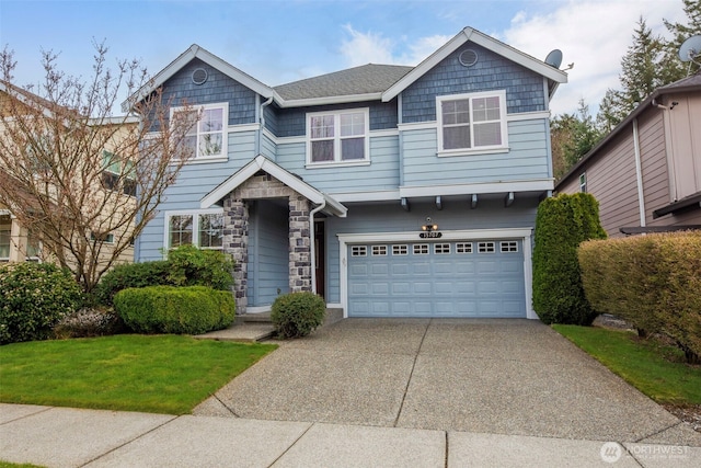 view of front of house with an attached garage, driveway, a front lawn, and stone siding