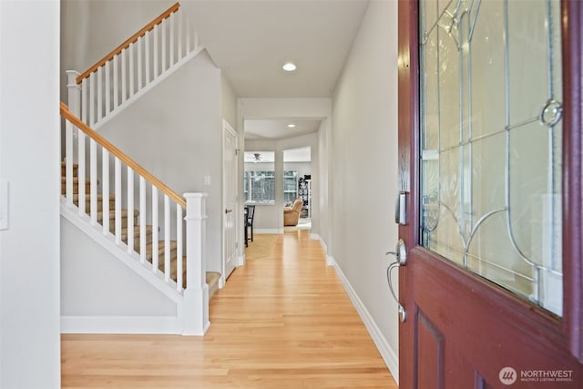 entrance foyer featuring light wood-type flooring, recessed lighting, stairs, and baseboards
