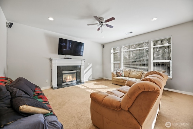 living room featuring a ceiling fan, baseboards, visible vents, and light carpet