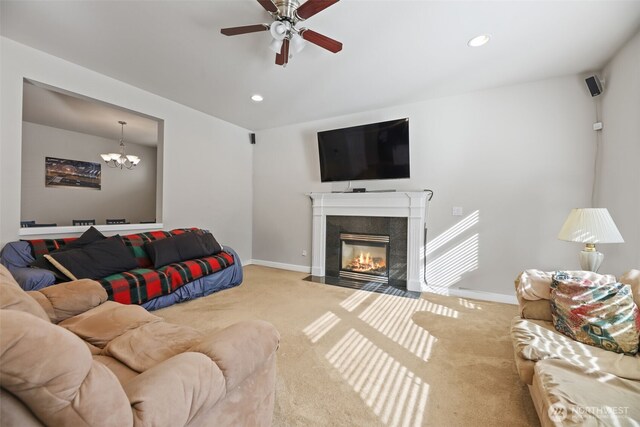 carpeted living room featuring recessed lighting, baseboards, ceiling fan with notable chandelier, and a premium fireplace