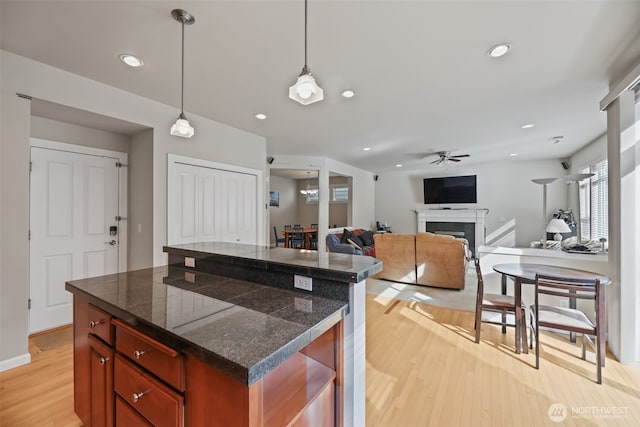 kitchen with ceiling fan, a fireplace, light wood-type flooring, tile counters, and recessed lighting