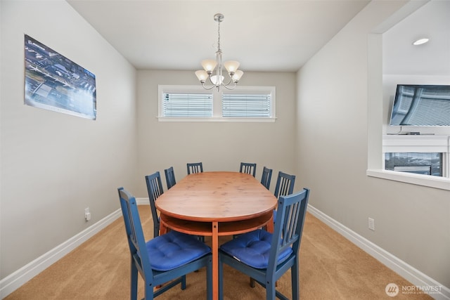 dining room featuring baseboards, light carpet, and a notable chandelier
