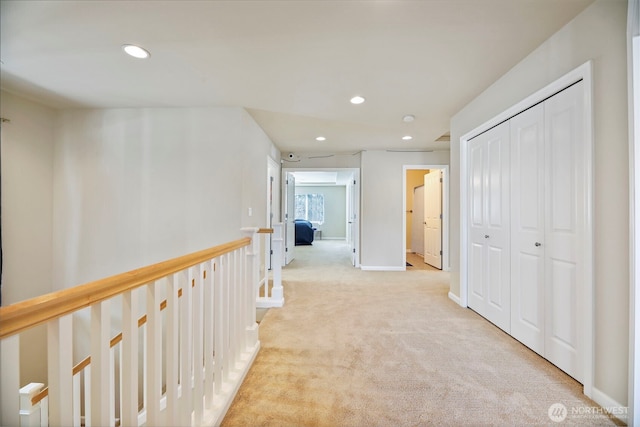 corridor with baseboards, carpet flooring, recessed lighting, and an upstairs landing