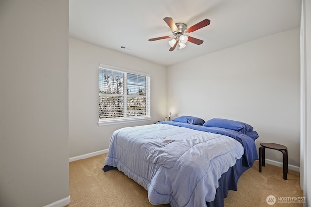 bedroom with baseboards, a ceiling fan, visible vents, and light carpet