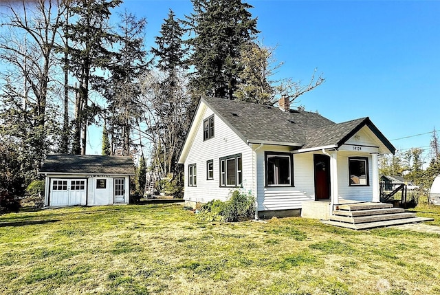 bungalow-style house featuring a front yard, an outdoor structure, a chimney, and a shingled roof