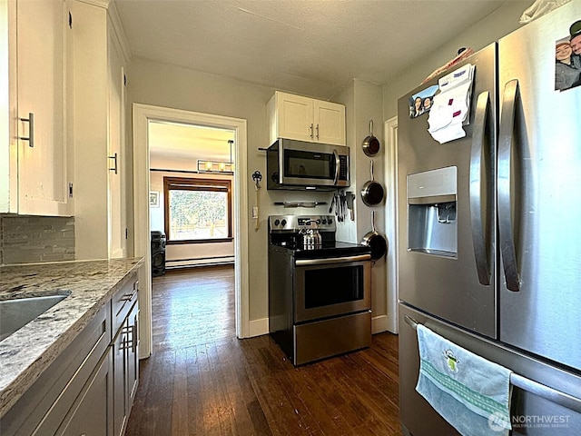 kitchen featuring stainless steel appliances, dark wood-type flooring, white cabinetry, and light stone countertops