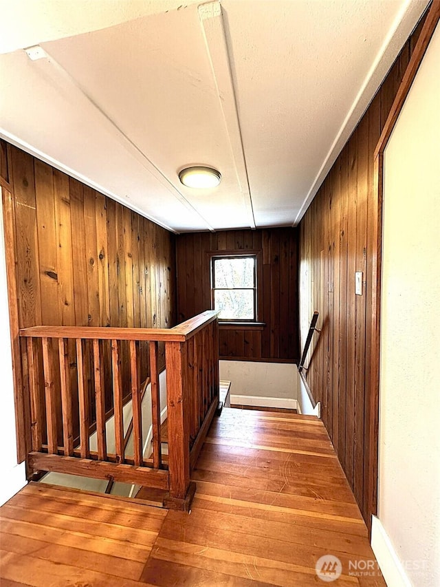 staircase featuring hardwood / wood-style flooring and wood walls