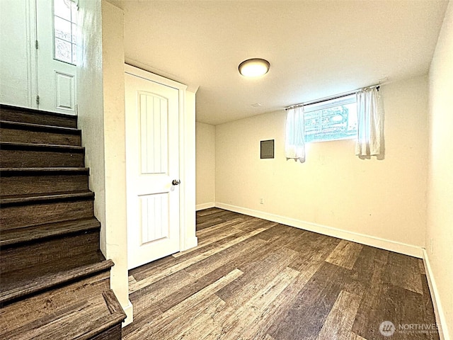basement with wood finished floors, baseboards, and stairs