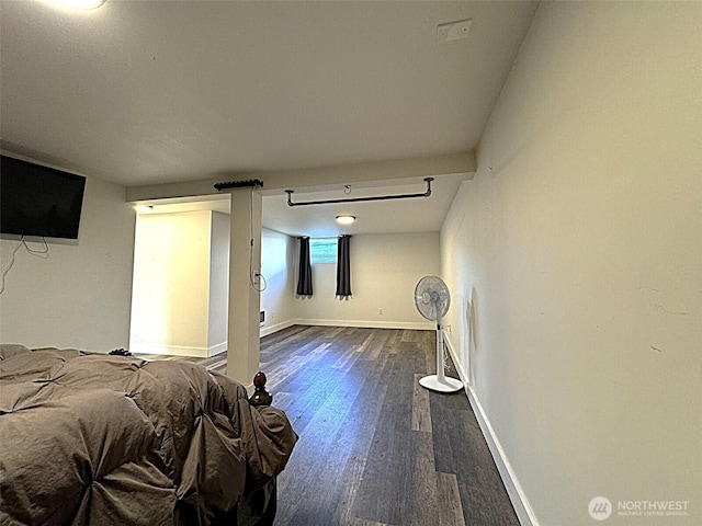 bedroom with dark wood-type flooring and baseboards