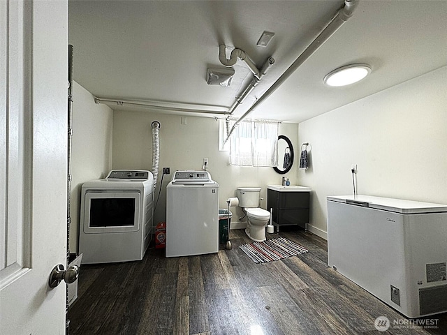 laundry area featuring washer and clothes dryer and dark wood-style floors