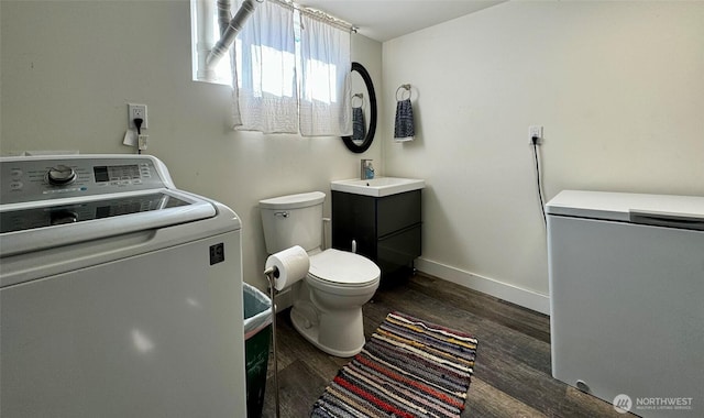 bathroom featuring washer / clothes dryer, wood finished floors, toilet, vanity, and baseboards