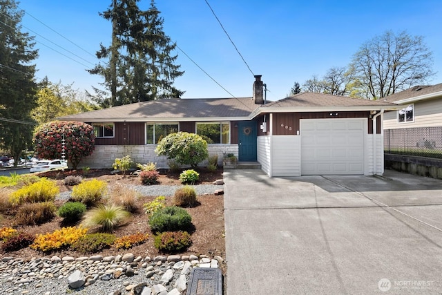 ranch-style house featuring a garage, a chimney, and concrete driveway