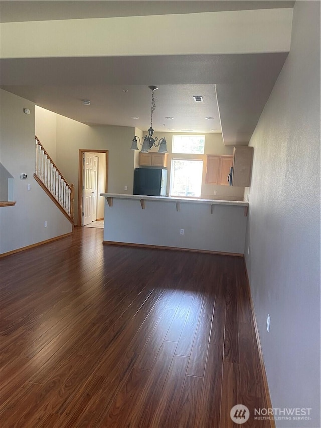 11406 SE 171st St Unit 14, Renton, WA 98058 - unfurnished living room with an inviting chandelier, visible vents, dark wood-style flooring, baseboards, and stairs