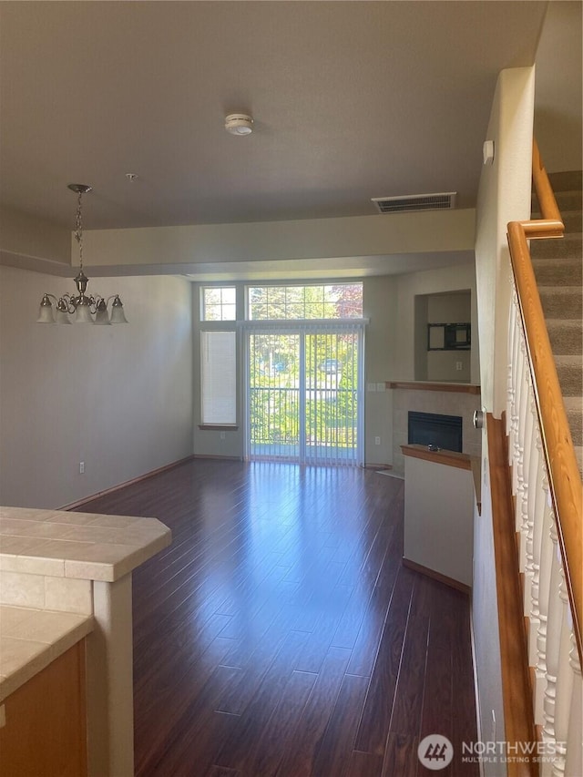 11406 SE 171st St Unit 14, Renton, WA 98058 - unfurnished living room featuring stairway, baseboards, dark wood finished floors, visible vents, and a tile fireplace
