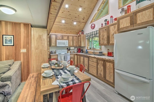 124 Aspen Ln, Packwood, WA 98361 - kitchen with light wood-style floors, white appliances, light countertops, high vaulted ceiling, and brown cabinetry