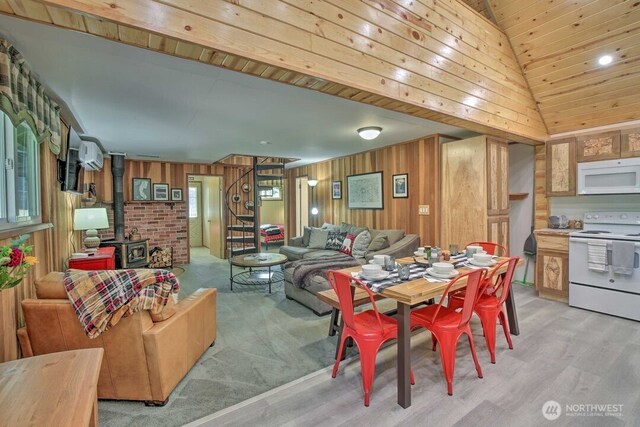124 Aspen Ln, Packwood, WA 98361 - dining area with wooden walls, a wood stove, and light wood-type flooring