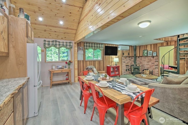 124 Aspen Ln, Packwood, WA 98361 - dining area featuring a wood stove, wooden walls, recessed lighting, a wall mounted AC, and light wood finished floors