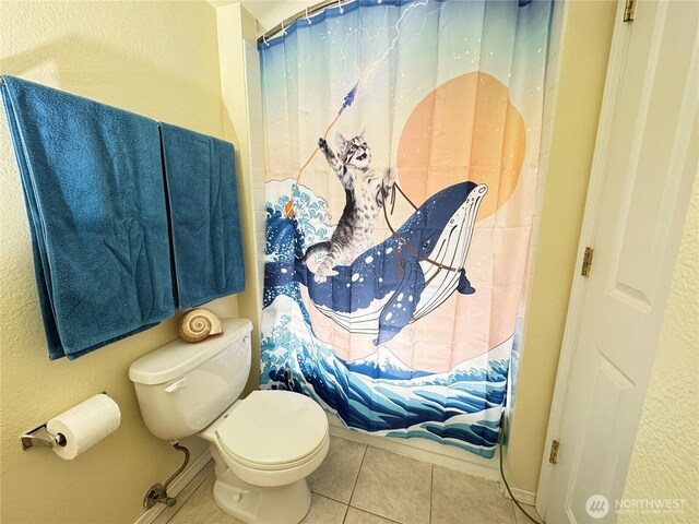 bathroom featuring tile patterned flooring, baseboards, curtained shower, and toilet