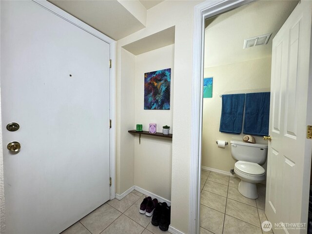 bathroom featuring visible vents, baseboards, tile patterned floors, and toilet