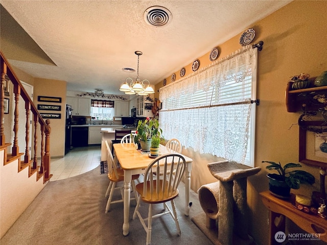 dining room featuring a textured ceiling, visible vents, a chandelier, stairway, and light colored carpet