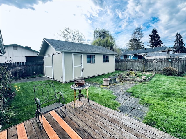 wooden terrace with a yard, an outdoor structure, and a fenced backyard