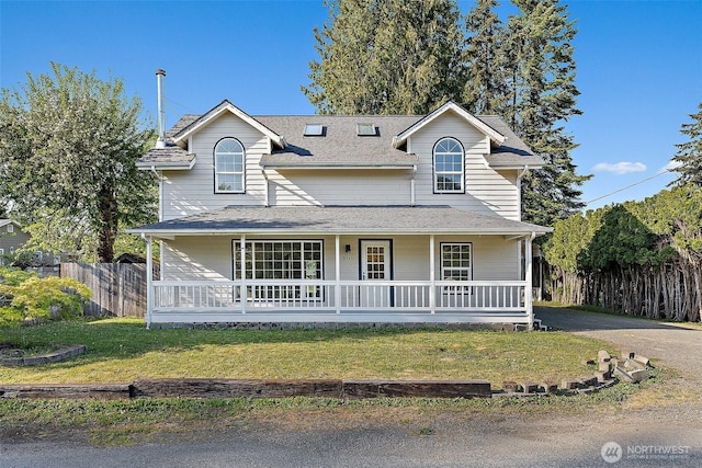 view of front of home featuring a porch, fence, and a front yard