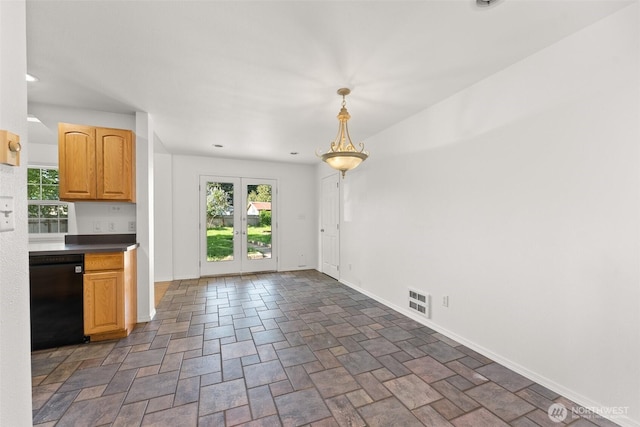 unfurnished dining area featuring baseboards, visible vents, stone finish flooring, and a wealth of natural light