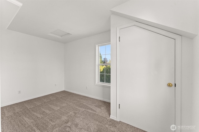 unfurnished bedroom featuring baseboards, carpet, and attic access
