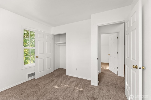 unfurnished bedroom with carpet floors, baseboards, a closet, and visible vents