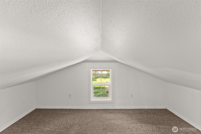 bonus room with carpet floors, baseboards, a textured ceiling, and lofted ceiling