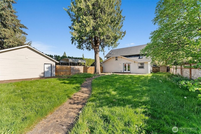 view of yard with a fenced backyard and french doors
