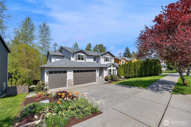 traditional-style house with fence, stone siding, a front yard, a shingled roof, and concrete driveway