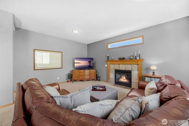 living room with baseboards, carpet, and a tile fireplace