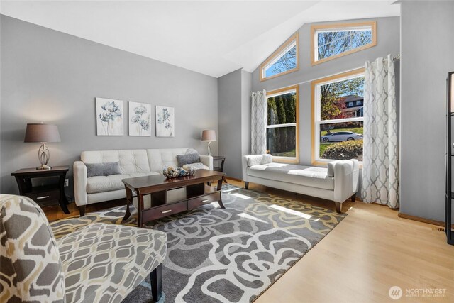 living room with high vaulted ceiling and wood finished floors