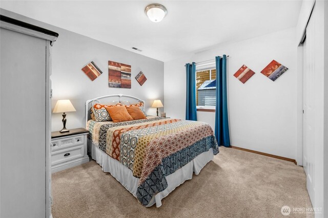 bedroom featuring baseboards, visible vents, and light carpet
