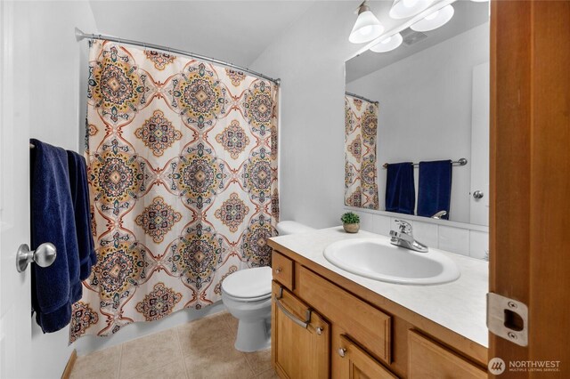 full bathroom featuring a shower with curtain, tile patterned floors, vanity, and toilet