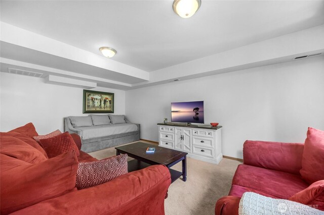 living room featuring baseboards, visible vents, and light carpet