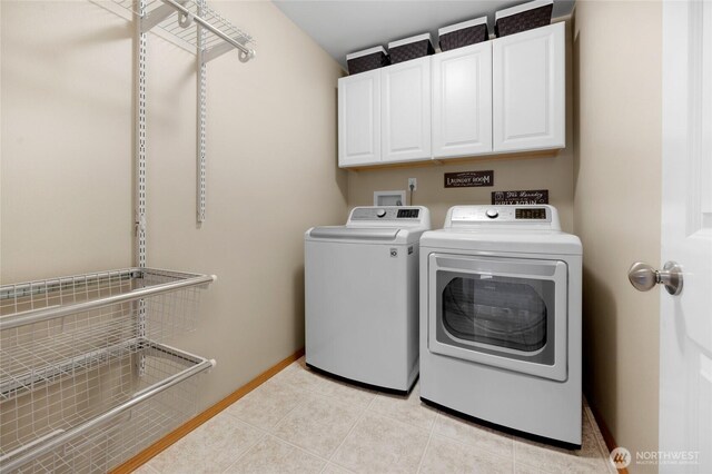 clothes washing area featuring baseboards, cabinet space, light tile patterned floors, and washer and dryer