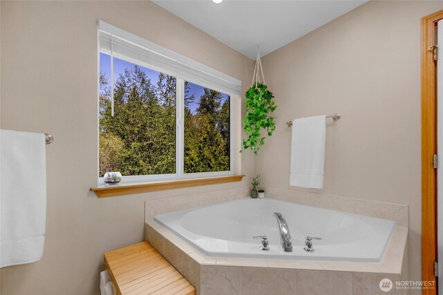 full bath featuring plenty of natural light and a bath