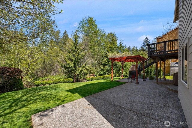 view of yard with a wooden deck, stairs, and a patio area