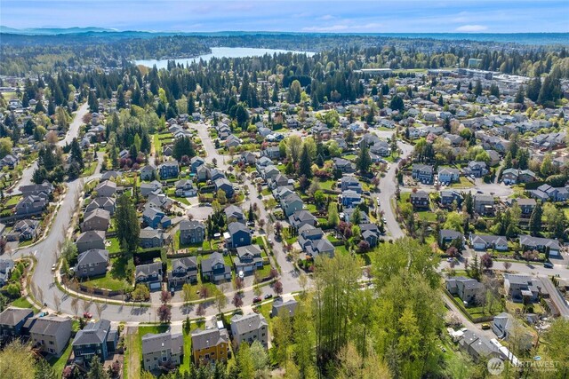 drone / aerial view with a forest view, a water view, and a residential view