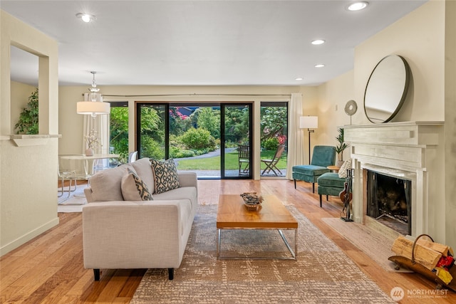 living area featuring recessed lighting, wood finished floors, a wealth of natural light, and a fireplace