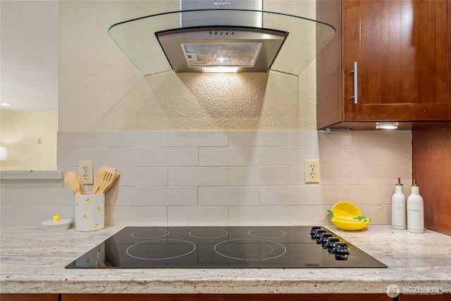 kitchen with decorative backsplash, brown cabinetry, and black electric cooktop
