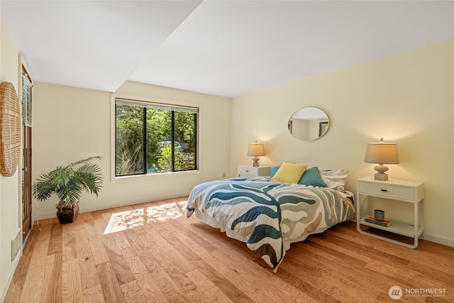 bedroom with baseboards and hardwood / wood-style flooring